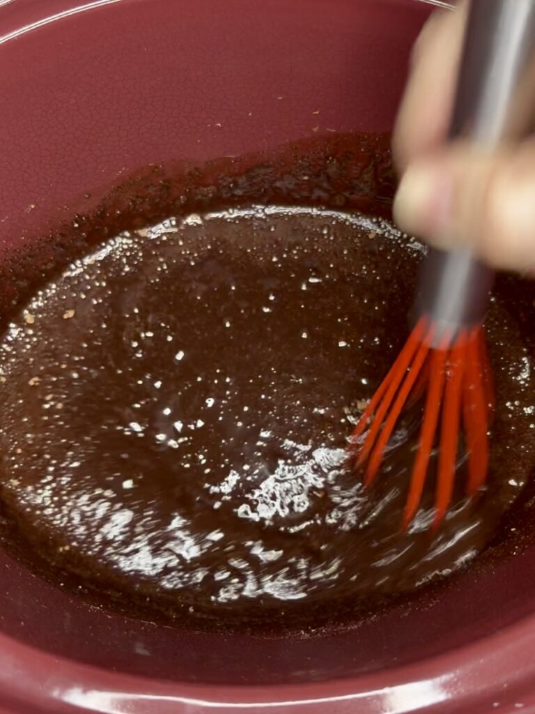 water, cocoa, and sugar being whisked